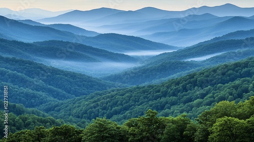 Majestic mountain ranges with layered blue ridges and a misty atmosphere, capturing the serene beauty of towering peaks and natural landscapes in the early morning light photo