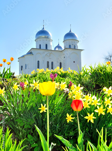 Veliky Novgorod Russia. St. George's Cathedral, Russian orthodox Yuriev Monastery in Veliky Novgorod, Russia - spring architectural landscape with flowers on the foreground photo