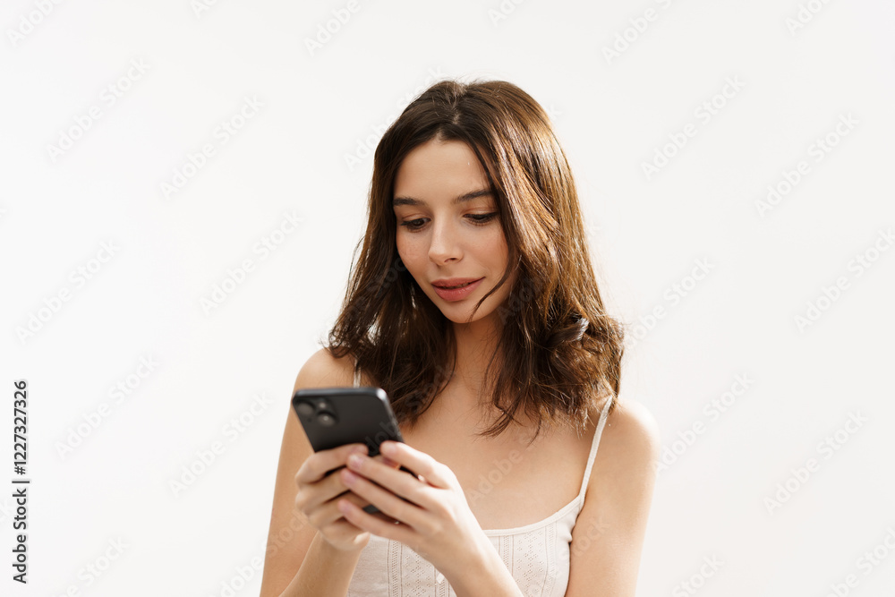 Young brunette woman in a white light top posing against a white background, expressing emotions and touching her face with her hands. Minimalistic and natural beauty concept Young brunette woman in a white light top posing against a white background, expressing emotions and touching her face with her hands. Minimalistic and natural beauty concept