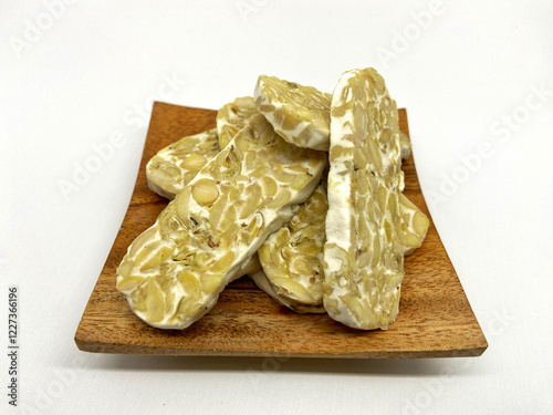 raw tempeh cut into pieces on a white background