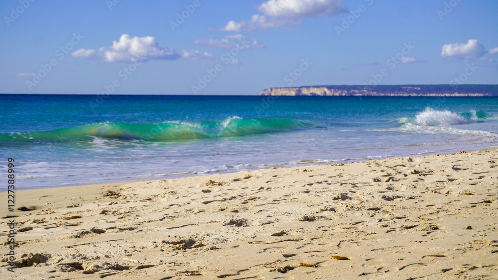 A beautiful beach with soft, white sand and crystal-clear turquoise water. Gentle waves lap at the shore, creating a tranquil atmosphere. In the distance, a rocky headland rises from the sea.
A beautiful beach with soft, white sand and crystal-clear turquoise water. Gentle waves lap at the shore, creating a tranquil atmosphere. In the distance, a rocky headland rises from the sea.