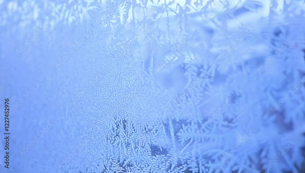 A macro shot of crystalline frost patterns on a window, illuminated by soft blue and white light. Intricate and wintery,