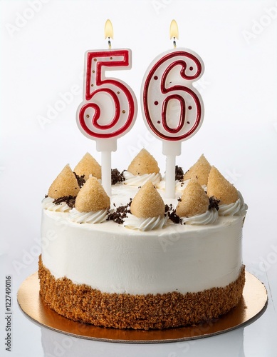 Decorated white cake for birthday or anniversary party, candle number 56, white background photo