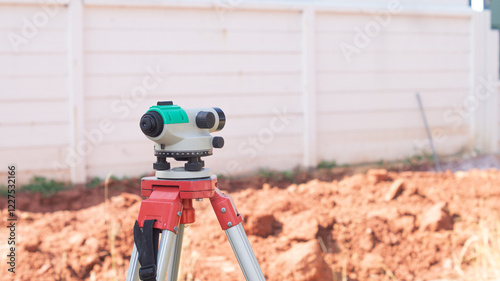 surveyor's telescope for measuring the height of areas in construction sites, houses, buildings, and equipment concepts for work The background is the wall and the ground.