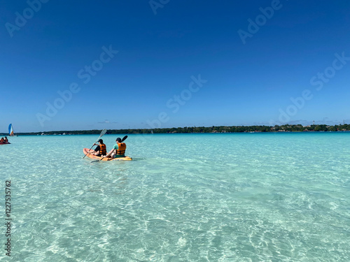 Two Kayakers Paddling Through a Tranquil Turquoise Lagoon