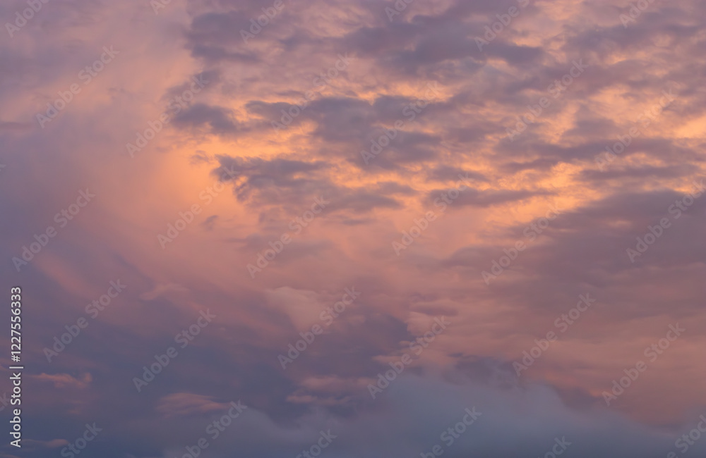 Fototapeta premium blue sky at dusk with a group of storm clouds in orange tones