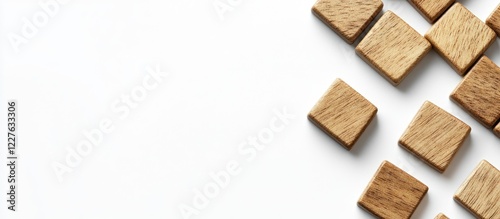 Wooden scrabble tiles arranged on a white background with ample negative space for text or design elements.
