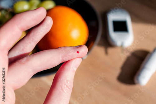 Woman pricking her finger to check blood glucose level with glucometer, test blood glucose for diabetes photo