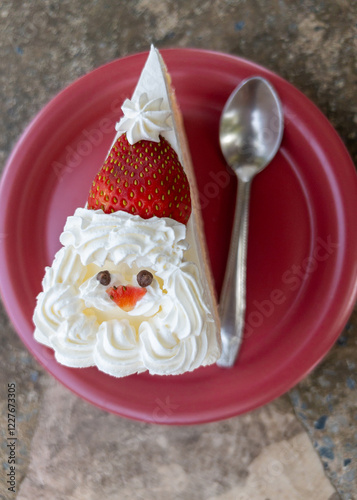 Strawberry Cream Cake Decorated as Santa Claus Face on a Red Plate.