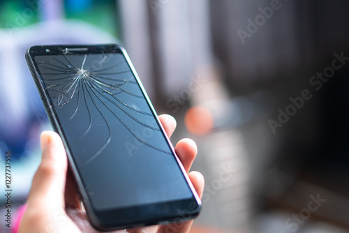 Smart phone with Cracked Screen Held in Hand