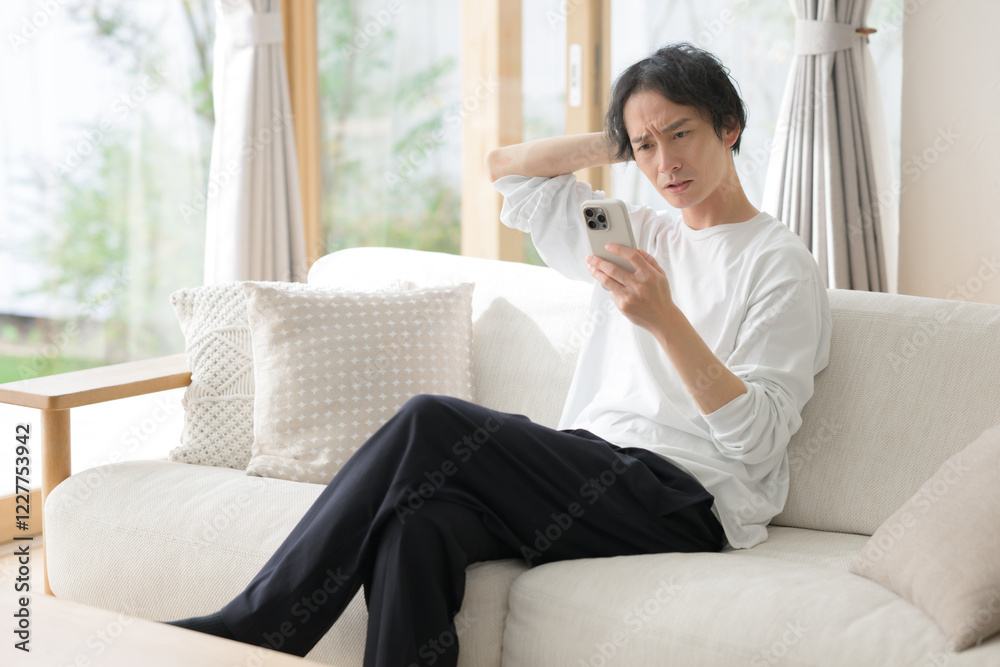 スマホを使う男性　悩む　困る