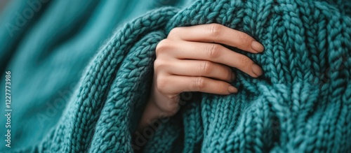 Close-up of a female hand knitting a teal fabric, showcasing texture and detail, perfect for crafting and knitting themed content. photo