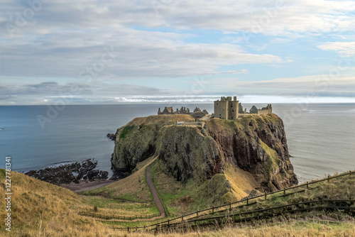 Dunnottar castle a ruined medieval fortress located upon a rocky headland on the northeast coast of Scotland .