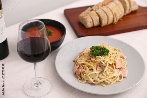 A delicious gourmet plate of Italian spaghetti pasta with tomato sauce, garnished with fresh green basil and cheese for a healthy restaurant lunch or dinner dish