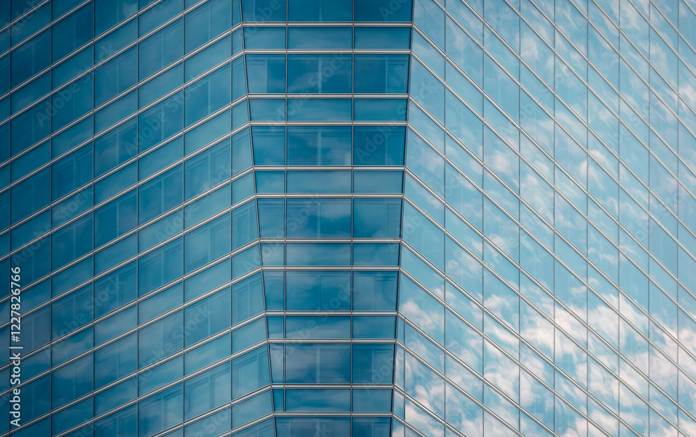 Geometric glass facade reflecting sky and clouds in downtown Geometric glass facade reflecting sky and clouds in downtown