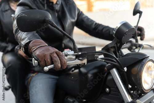 Biker wearing leather gloves and jacket driving motorcycle