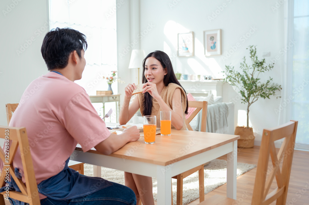 Couple Enjoys a Cheerful Breakfast at a Bright, Modern Dining Table in a Cozy Home Setting Couple Enjoys a Cheerful Breakfast at a Bright, Modern Dining Table in a Cozy Home Setting