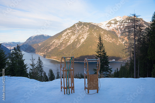 Schilderij op canvas two wooden sledges at the  tobogganing run Pertisau, Tyrol with a view of Lake A