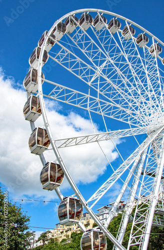 Funfair Ferris wheel.  Amazing structure in brilliant sunshine, a holidaymakers dream. A great example of ornate construction, and steelwork. photo