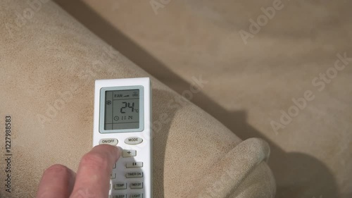 Wallpaper Mural Male hand adjust a temperature on remote control. A view of person in the room adjust the temperature on remote controller. Torontodigital.ca