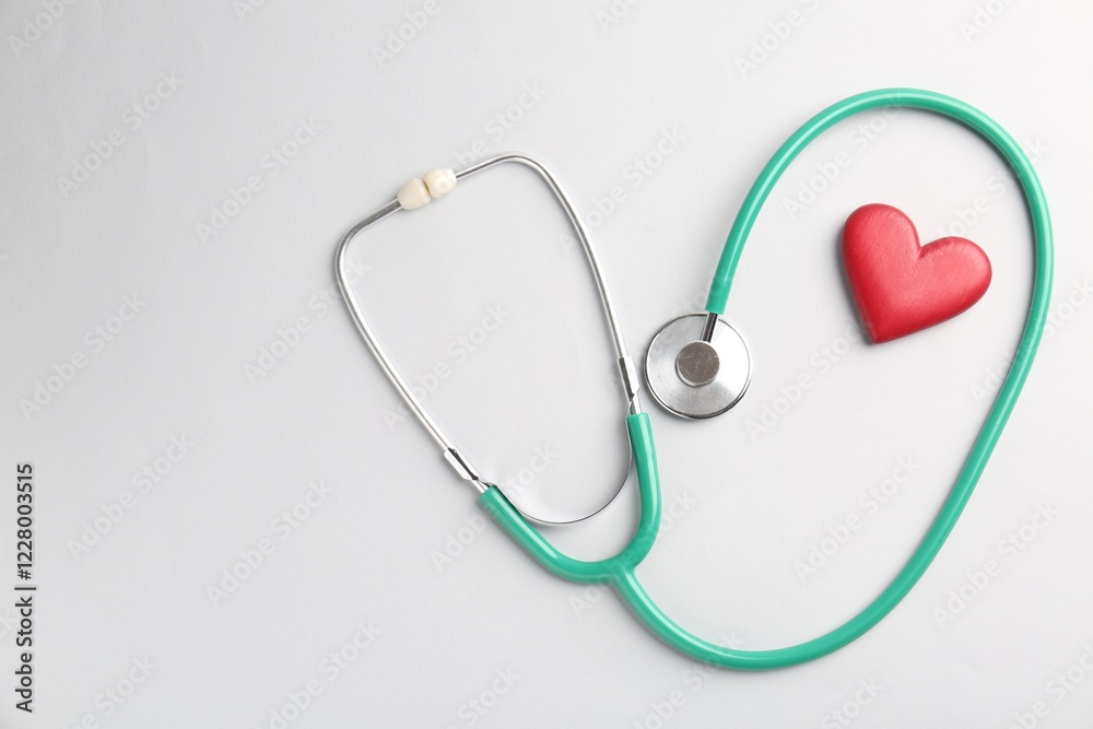 Cardiology. Stethoscope and red decorative heart on white background, flat lay. Space for text Cardiology. Stethoscope and red decorative heart on white background, flat lay. Space for text