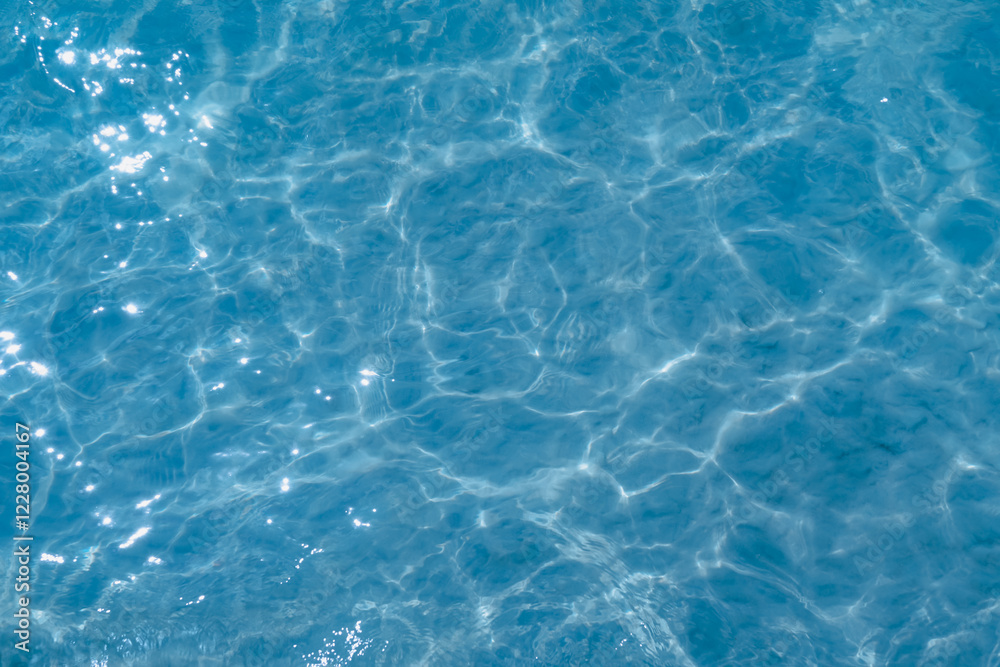 Overhead view of blue water surface abstract. Wave on moving water surface close up in the middle of the screen. Blue ocean water with waves background Overhead view of blue water surface abstract. Wave on moving water surface close up in the middle of the screen. Blue ocean water with waves background