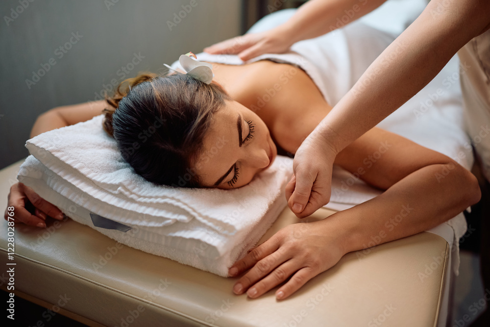 Young woman relaxing during massage at wellness spa. Young woman relaxing during massage at wellness spa.