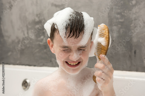 Принти на полотні Smiling child enjoying bath time with foam on his head and face, playfully holding a wooden comb