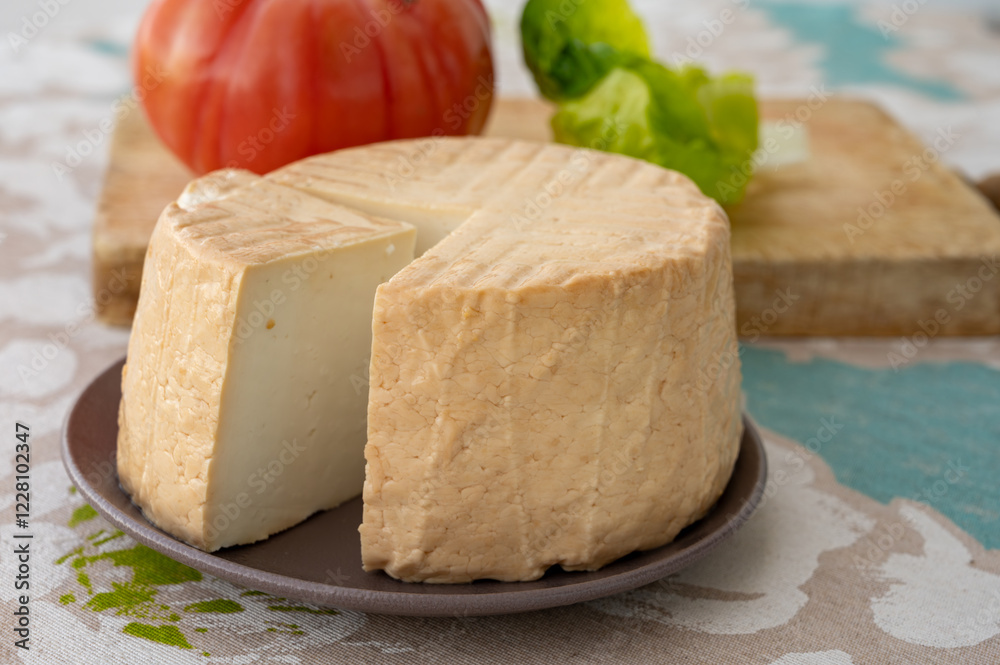 Cheese collection, piece of round fresh smoked Spanish goat cheese close up Cheese collection, piece of round fresh smoked Spanish goat cheese close up