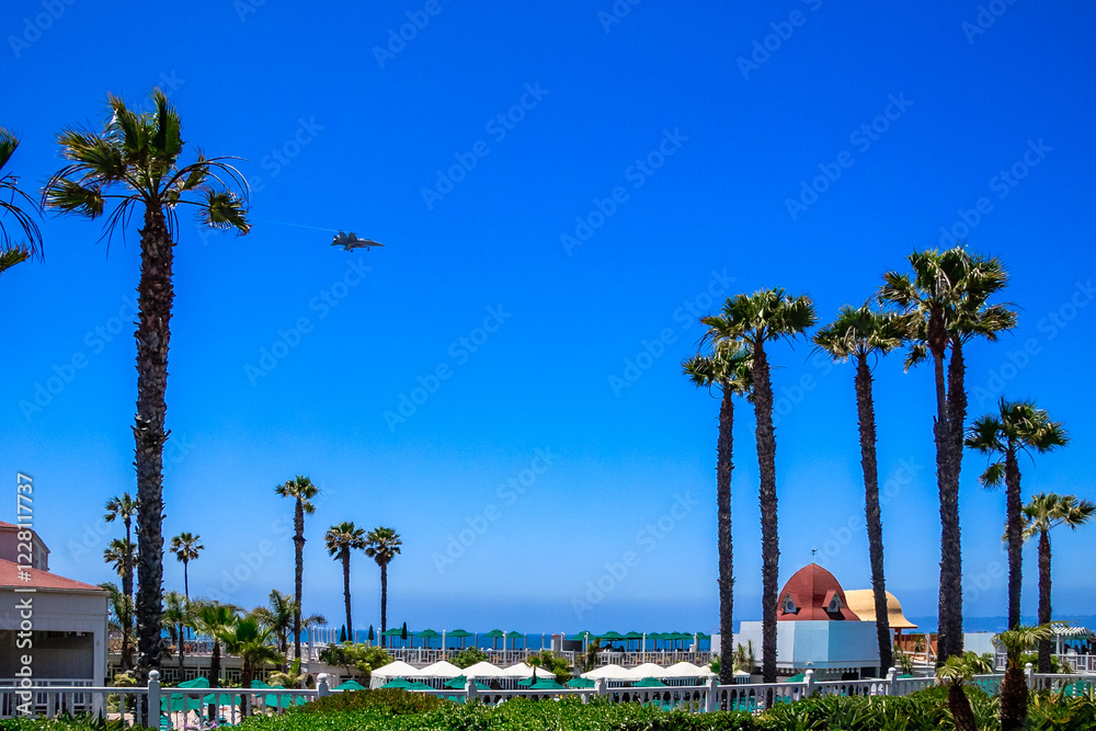 Obraz premium A blue sky with palm trees and a white building in the background