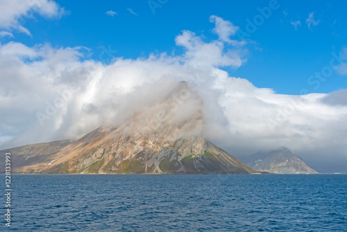 Rocky Coastal Peak Engulfed in Coasted Clouds