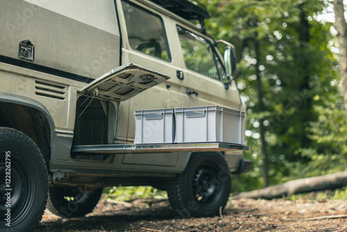Obraz na płótnie Two plastic euro box on a pull out drawer of a vintage adventure offroad vehicle or motor home, parked outside in a forest w salonie