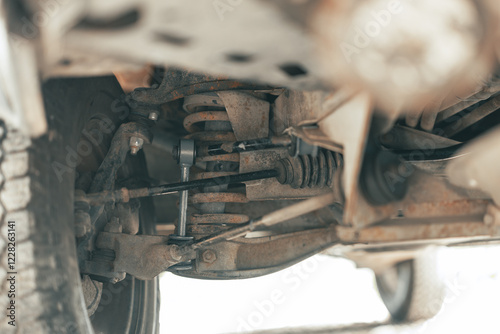 Obraz na płótnie Front view of a new stabilizer bar and link of a double wishbone suspension of a van or a truck. visible suspension components such as rack, spring, wheel,... w salonie
