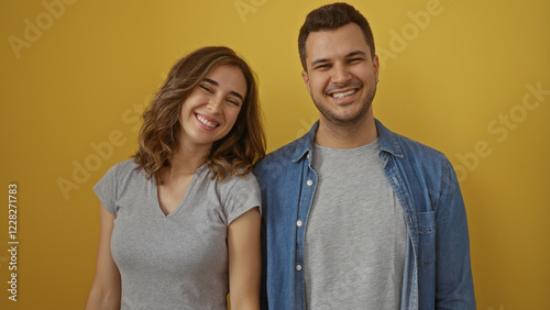 Man and woman smiling together against a yellow background, showcasing love and joy in a happy relationship. photo