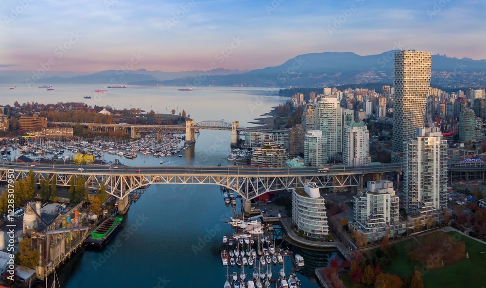 Naklejka premium Vancouver skyline at dawn, featuring the Granville Bridge, numerous boats, and modern high-rise buildings. Cityscape, bridge, and harbor. Vancouver, British Columbia, Canada