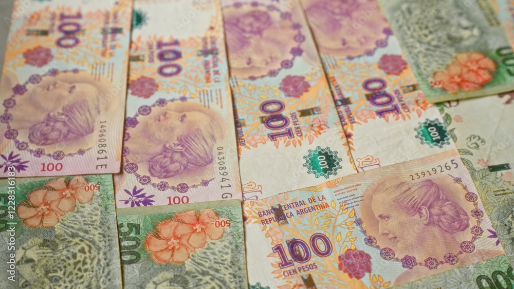 Obraz premium Argentinian banknotes in denominations of 100 and 500 pesos arranged closely together, showcasing vibrant colors and intricate designs, representing argentina's currency.