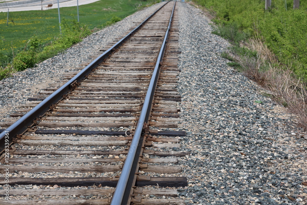 close-up view along a rail line with worn wooden ties and gravel bed close-up view along a rail line with worn wooden ties and gravel bed