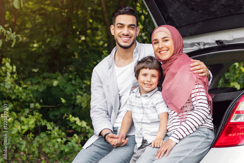 Rest and relax at road. Happy young arab male and female in hijab with small son sitting in car trunk, take break at trip, outdoor. Traveling together, family vacation at own auto, good offer and ad Rest and relax at road. Happy young arab male and female in hijab with small son sitting in car trunk, take break at trip, outdoor. Traveling together, family vacation at own auto, good offer and ad