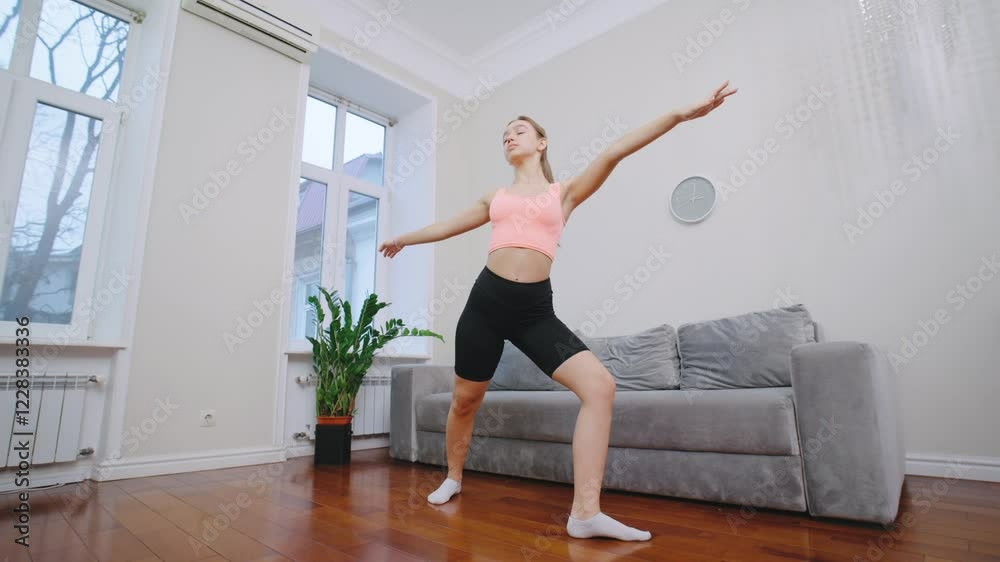 Young woman stretches in a cozy living room while preparing for a workout during the afternoon Young woman stretches in a cozy living room while preparing for a workout during the afternoon