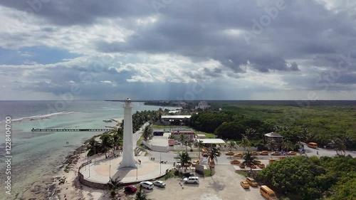 Lighthouse in Mahahual Mexico a long the shore of the caribbean sea at the cruise port of Costa Maya Mexico with downtown and the forest in the distance a peir going into the ocean with taxi parking