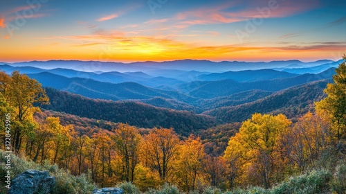 A panoramic shot of mountain ranges stretching to the horizon, bathed in warm light under a fiery sunset sky.