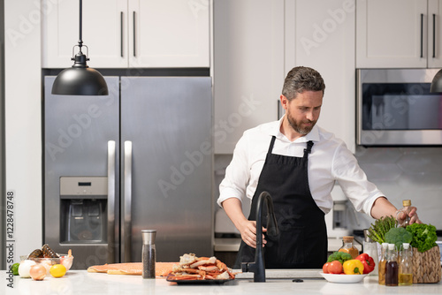 Man cook tasty meal. Home menu with seafood food. Man cook cooking at kitchen. Hispanic man standing in kitchen preparing sea food. Millennial man cook tasty crab. Healthy food diet, advertisement