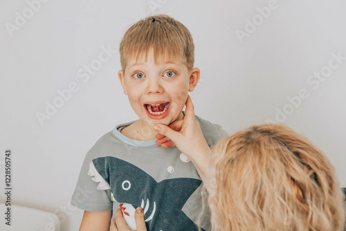 boy practicing speech therapy exercises while looking at in bright educational office with female therapist, concept of childhood development photo