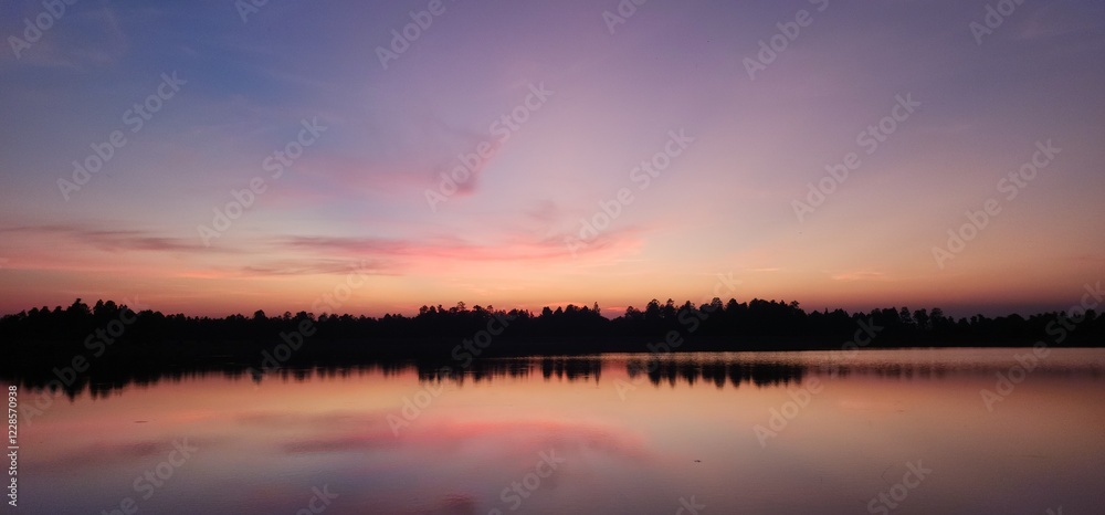 Stunning sunset over tranquil lake, reflecting warm hues of orange,pink,blue. Peaceful water and soft sky create serene and dreamy atmosphere, perfect for backgrounds, nature prints, landscape themes. Stunning sunset over tranquil lake, reflecting warm hues of orange,pink,blue. Peaceful water and soft sky create serene and dreamy atmosphere, perfect for backgrounds, nature prints, landscape themes.