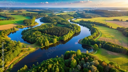 Fototapeta Naklejka Na Ścianę i Meble -  Aerial view of Mazury's vast and serene landscape with rolling hills, forests, and a winding river