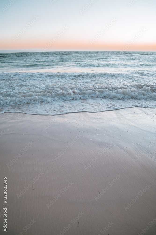 Beautiful ocean waves crash into a sandy beach during sunrise in tropical Punta Cana, Dominican Republic. Beautiful ocean waves crash into a sandy beach during sunrise in tropical Punta Cana, Dominican Republic.