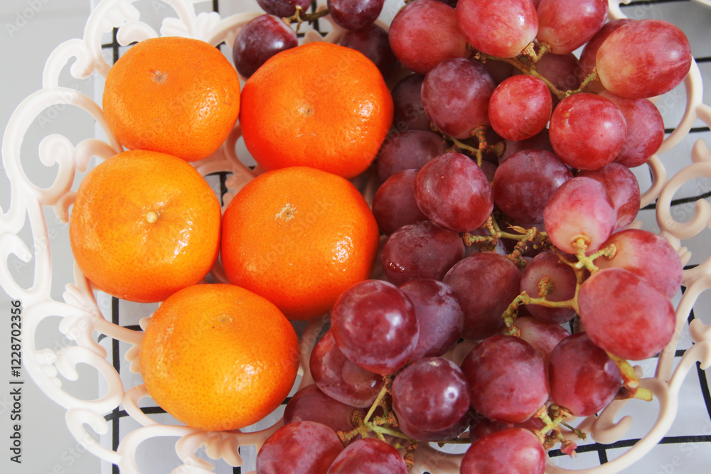 Red grapes and oranges collected in one fruit basket Red grapes and oranges collected in one fruit basket