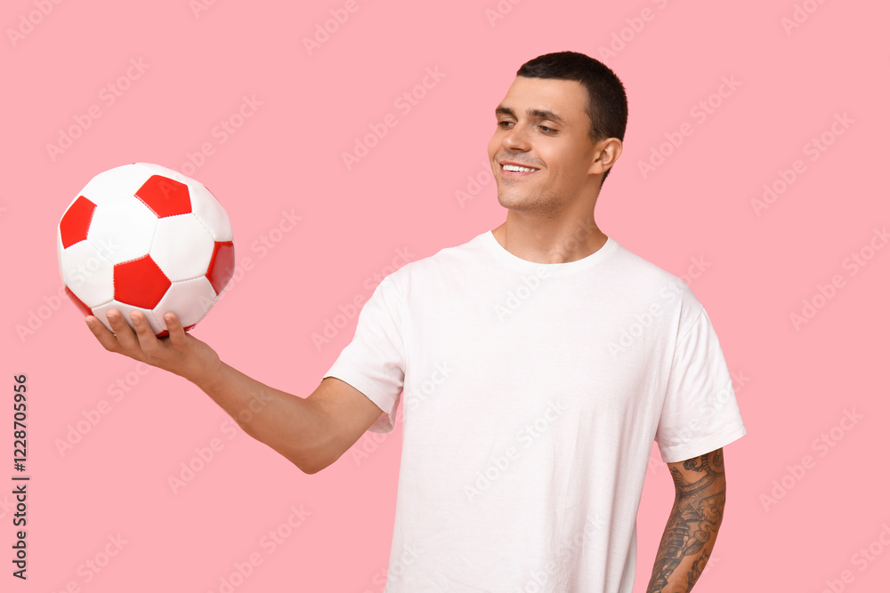 Handsome young man with soccer ball on pink background Handsome young man with soccer ball on pink background