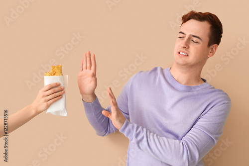 Young man rejecting sandwic...