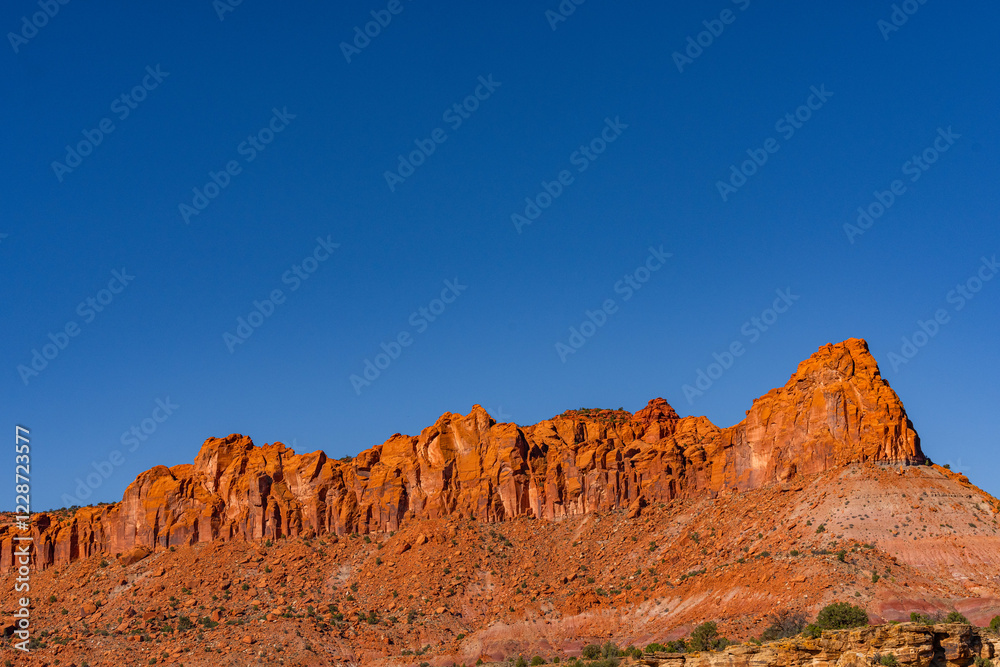 Naklejka premium red rock cliffs at the bottom and a large deep blue sky with lots of room for copy